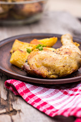 Baked chicken pieces with potatoes, herbs and garlic 