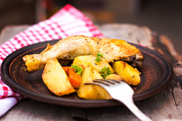 Baked chicken pieces with potatoes, herbs and garlic 