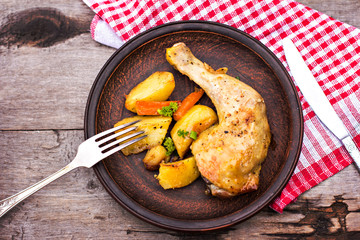 Baked chicken pieces with potatoes, herbs and garlic 