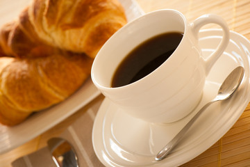 cup of coffee and croisants served for breakfast