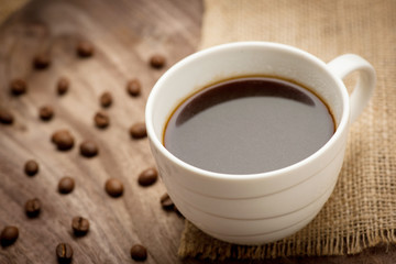 Cup of black coffee served on wooden table