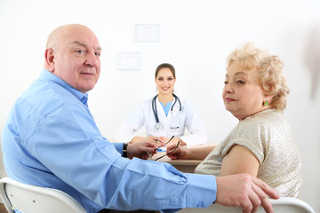 Happy doctor and patients in hospital clinic