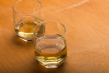 two glasses of whiskey on a wooden table
