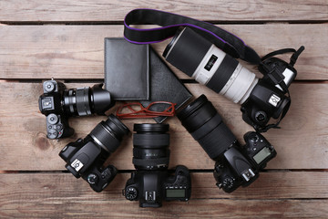 Still life with modern cameras on wooden table, top view