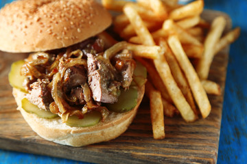 Tasty burger and french fries on wooden table background  Unhealthy food concept