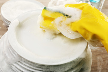 Female hand washing dish close up