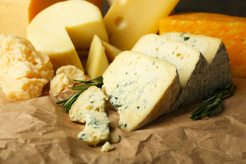 Various types of cheese with rosemary on table close up