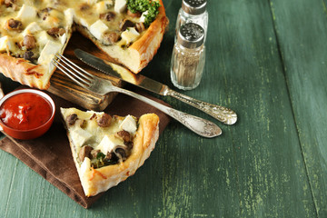 Cheese pie with mushrooms, herbs and sour creme, on color wooden table background