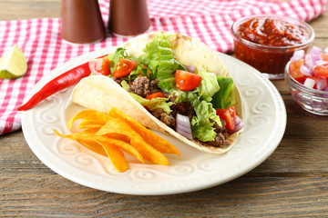 Mexican food Taco in plate on wooden table, closeup