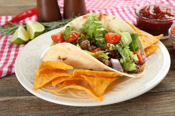 Mexican food Taco in plate on wooden table, closeup