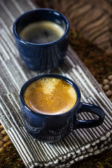 Two blue cups of coffee on napkin