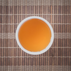 Cup of Chinese hot tea on bamboo mat background