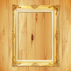 Antique gold frame on wooden wall;. Empty picture frame on woode