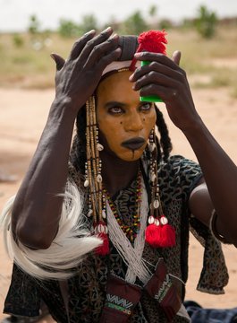 Wodaabe man checking makeup in a mirror, Gerewol, Niger