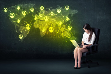 Businesswoman in office with laptop and social network world map
