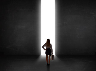 Business person looking at wall with light tunnel opening
