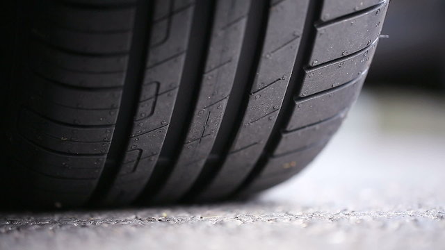 Car tyre tread on a road as cars pass by