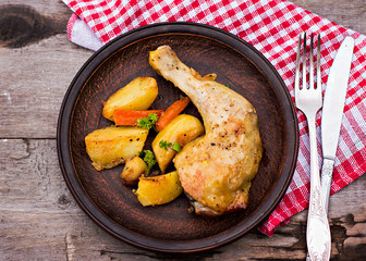 Baked chicken pieces with potatoes, herbs and garlic
