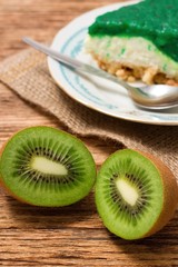 Fototapeta na wymiar Two halfs of Kiwi fruit in front of green cake