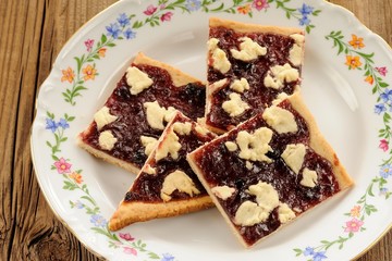 Berry jam cookies in white plate on wooden background closeup