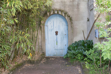 Fototapeta na wymiar An Old house grey wall with Blue door