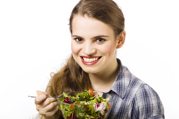 Beautiful, young woman eating vegetable salad