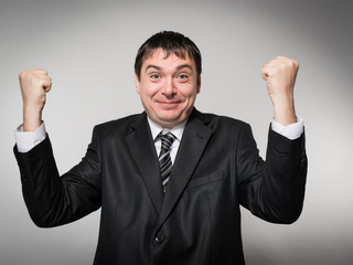 man in a suit raised both hands up the joy of victory delight