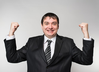 man in a suit raised both hands up the joy of victory delight