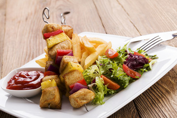 Grilled chicken skewers with pineapple, peppers and onions serve