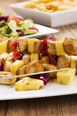 Grilled chicken skewers with pineapple, peppers and onions serve