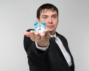 man holding an alarm clock in hands