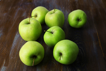 Green apples on wooden background