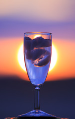Glass wine on sunrise background.