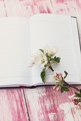 The sprigs of flowering apple-tree with a notebook