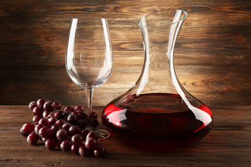 Glass carafe of wine on wooden background