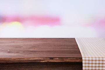 Empty wooden table with napkin and light background
