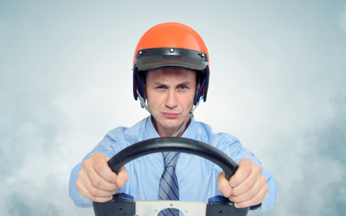 Businessman in a helmet with steering wheel, car drive concept