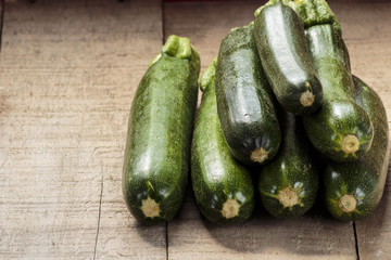 Green zucchini on wooden table, copy space