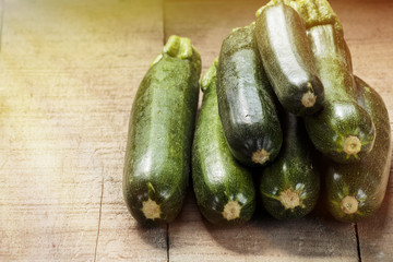 Green zucchini on wooden table, processed with sun glow effect