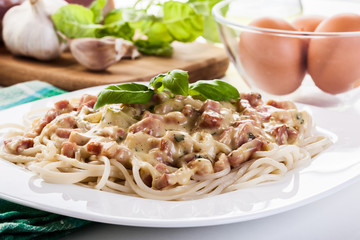 Spaghetti carbonara with bacon and basil
