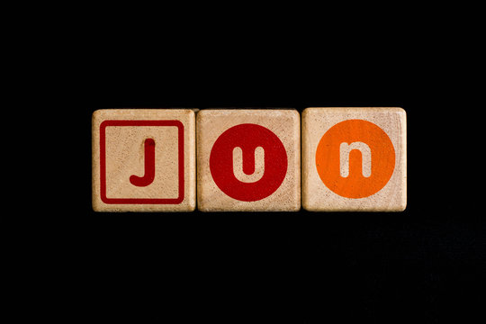 june on wood Cubic on black background
