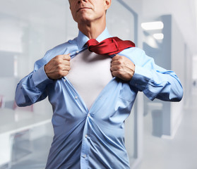 Superhero. Mature businessman tearing his shirt off
