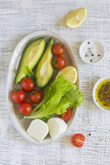 ingredients for a fresh salad with avocado and cherry tomatoes