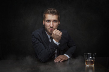 Attraktiver Geschäftsmann mit whiskey vor schwarzem Hintergrund