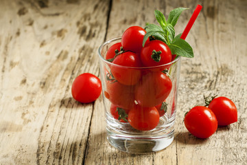 Funny cool tomato juice and tomatoes in a glass, selective focus