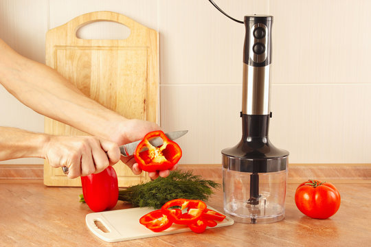 Hands cook cut bell pepper on the kitchen table