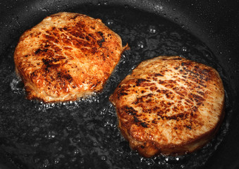 Steaks are fried in a skillet