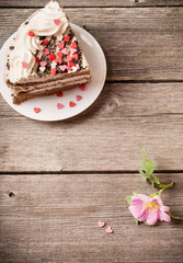 pink rose and cake on wooden background