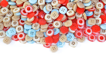 Pile of colorful plastic buttons on white background