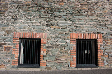 Hintergrund – irische Natursteinmauer mit Kellerfenstern